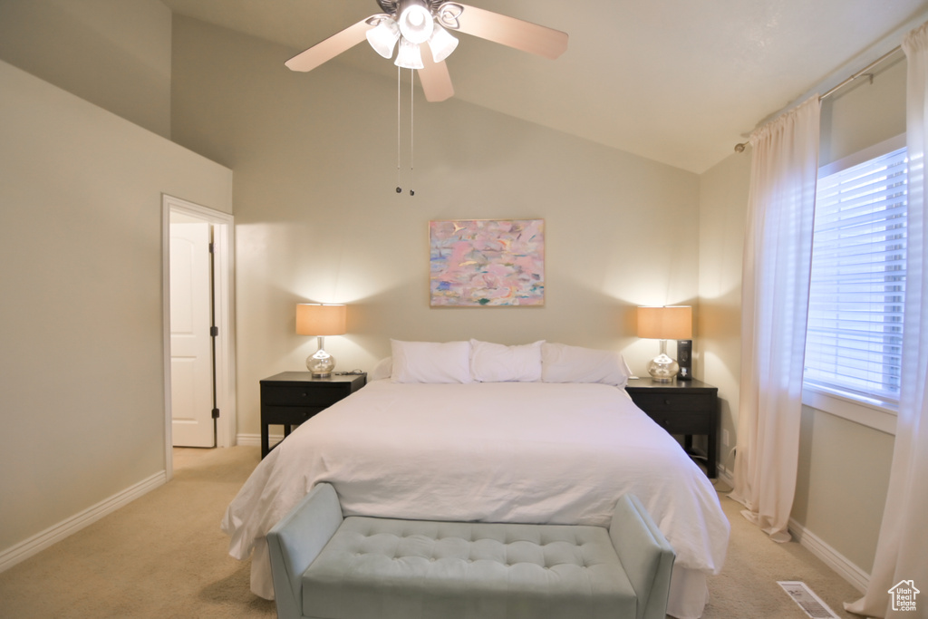 Bedroom with ceiling fan, lofted ceiling, baseboards, and light carpet