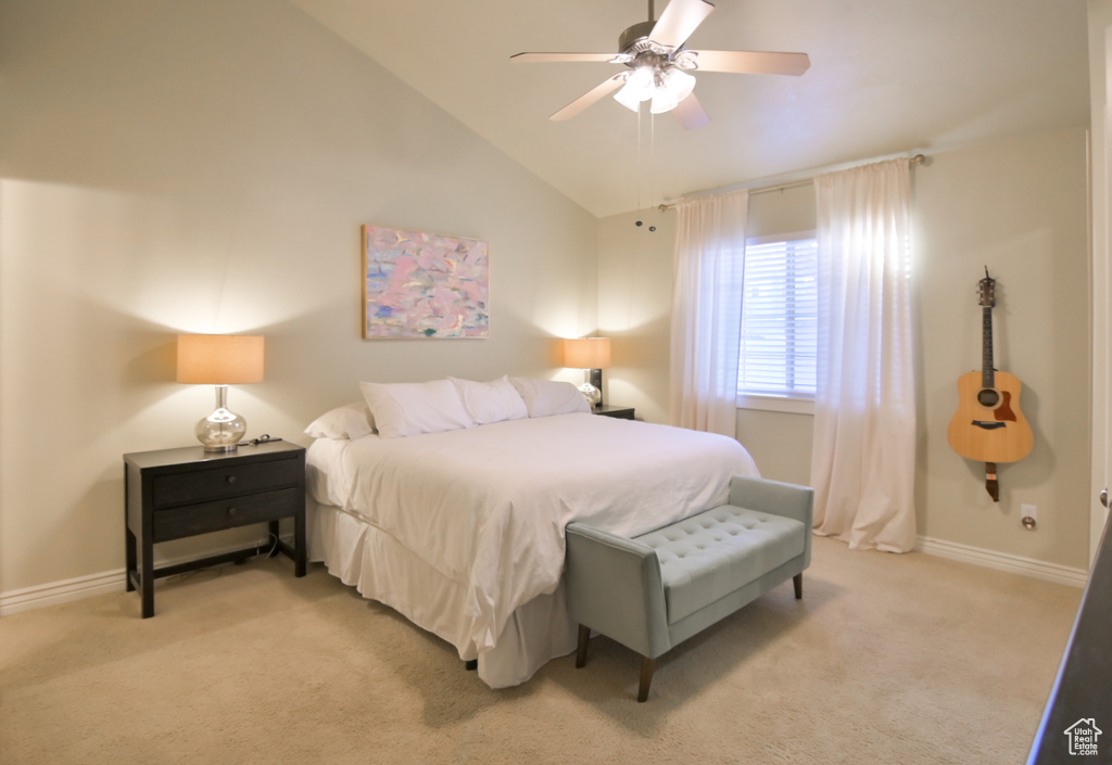 Bedroom with baseboards, lofted ceiling, and light colored carpet