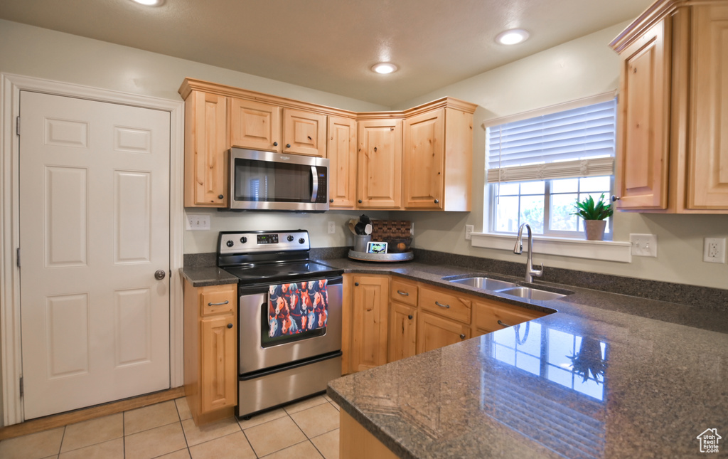 Kitchen with light tile patterned floors, light brown cabinets, recessed lighting, a sink, and stainless steel appliances
