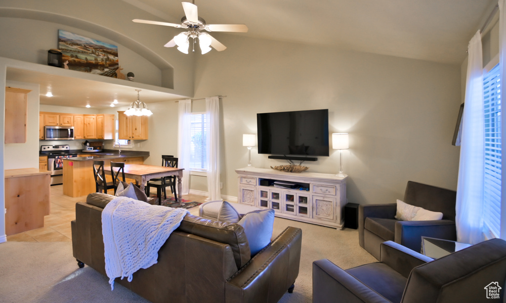 Living room with light colored carpet, baseboards, lofted ceiling, and ceiling fan