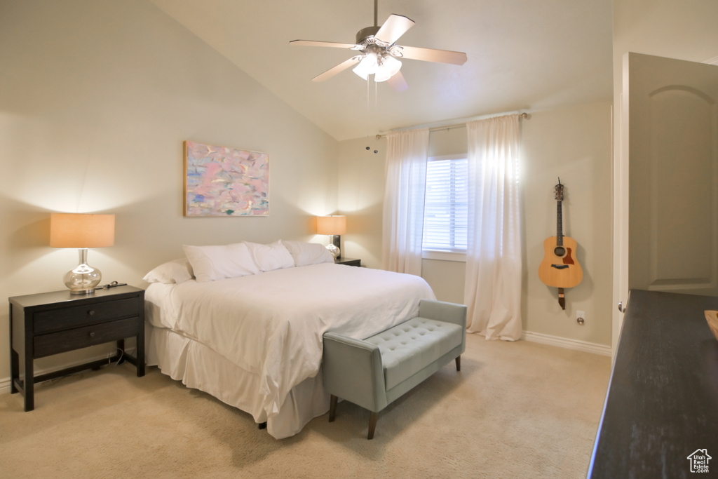 Bedroom featuring baseboards, light carpet, lofted ceiling, and a ceiling fan