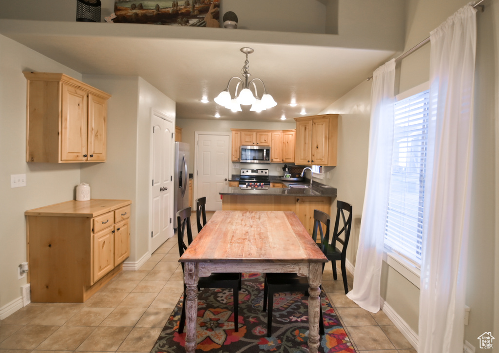 Dining area with light tile patterned floors, baseboards, plenty of natural light, and a chandelier