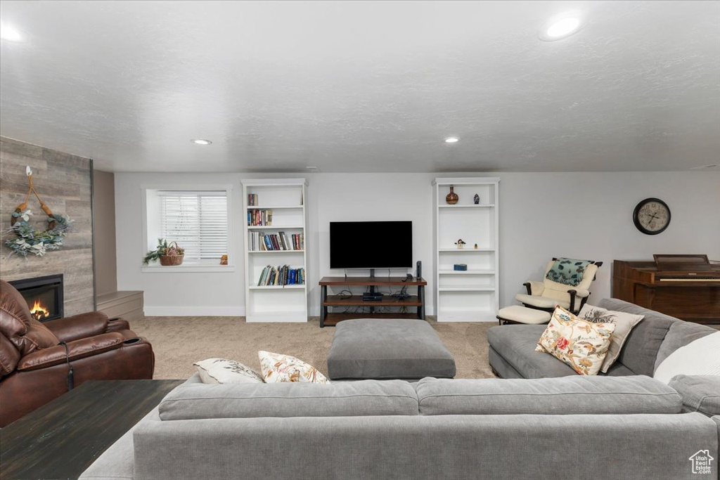 Living room featuring recessed lighting, a fireplace, baseboards, and carpet floors
