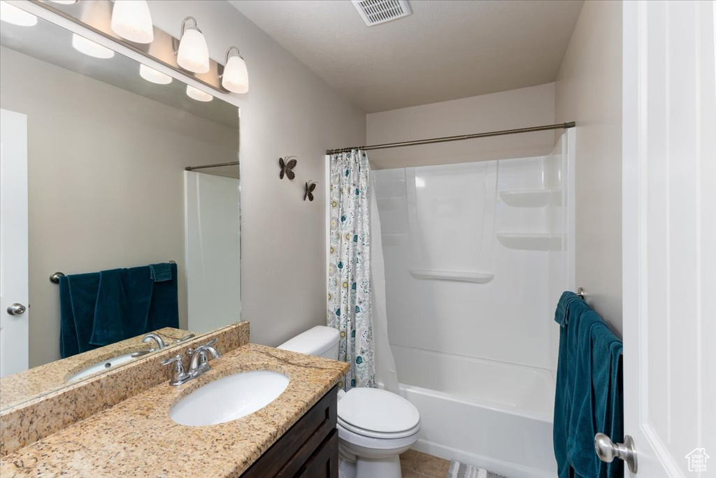 Full bathroom with visible vents, toilet, vanity, and shower / bath combination with curtain
