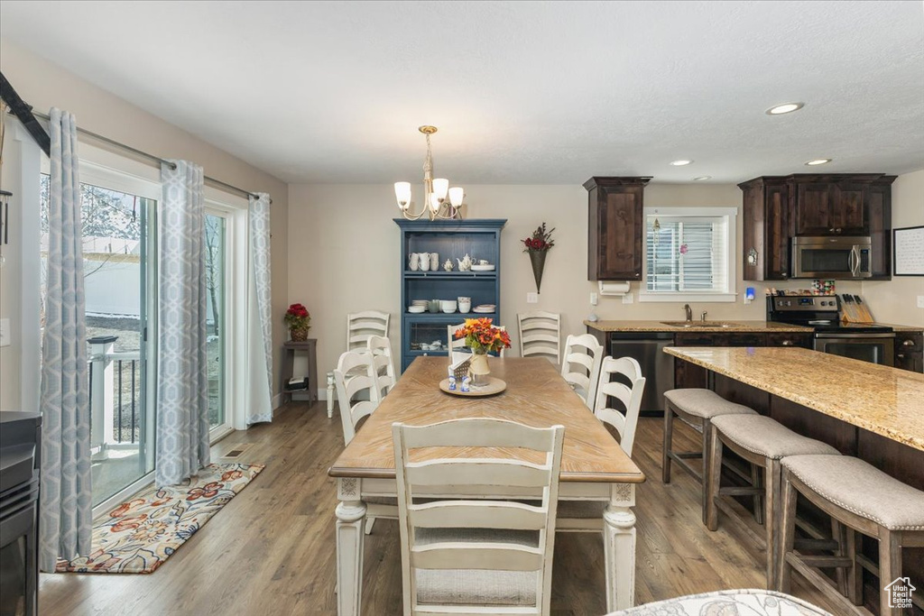 Dining space featuring a wealth of natural light, light wood-type flooring, and a chandelier