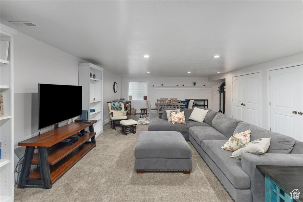 Carpeted living area with recessed lighting and visible vents