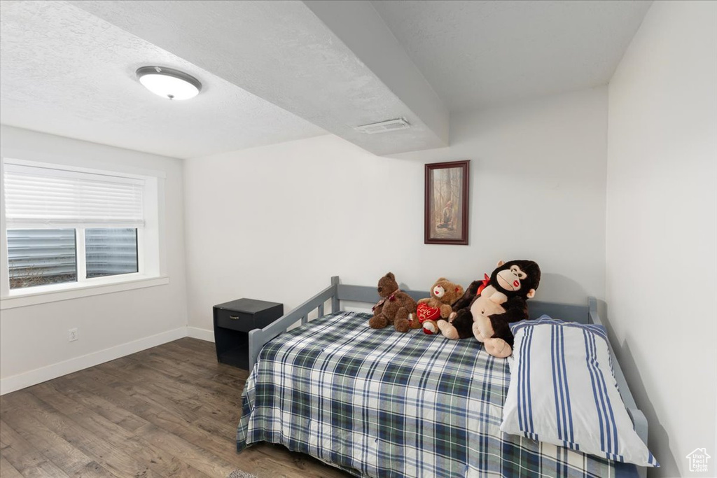 Bedroom featuring visible vents, wood finished floors, baseboards, and a textured ceiling