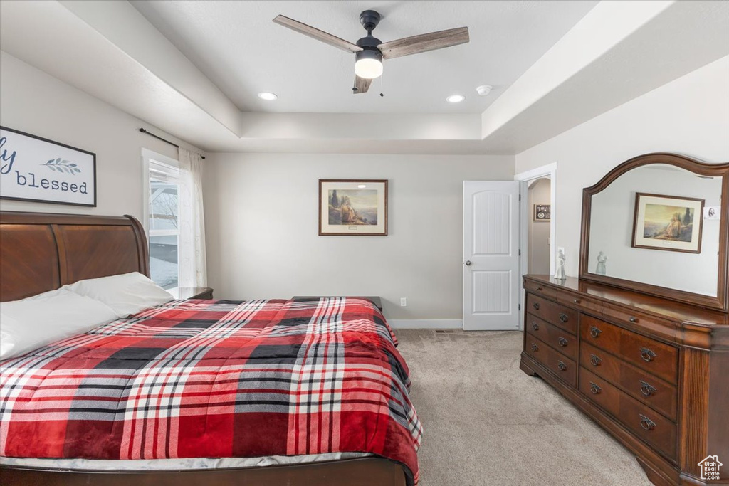 Bedroom with recessed lighting, baseboards, a raised ceiling, and light colored carpet
