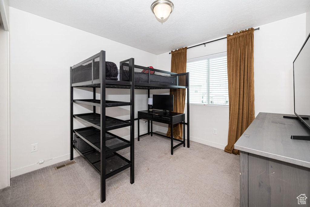 Bedroom with light colored carpet and baseboards