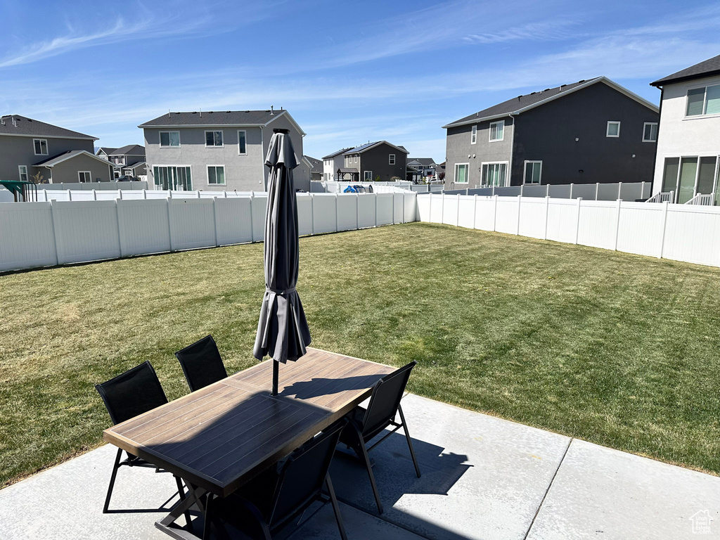 View of yard featuring a fenced backyard, a patio area, a residential view, and outdoor dining space