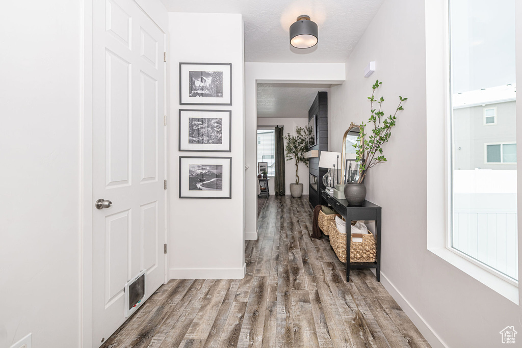 Corridor with visible vents, baseboards, and wood finished floors
