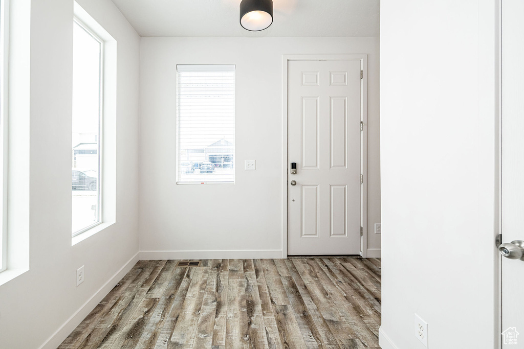 Entrance foyer featuring visible vents, baseboards, and wood finished floors