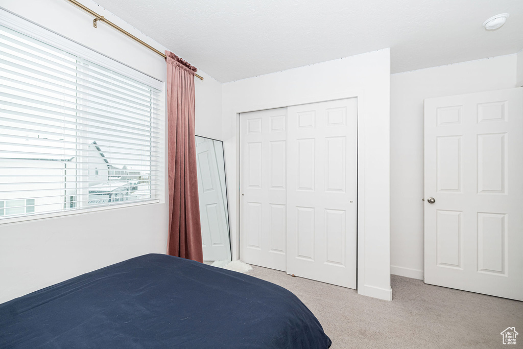 Bedroom featuring a closet, carpet flooring, and baseboards