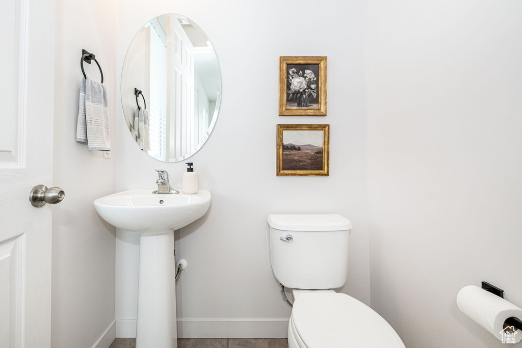 Half bath with baseboards and toilet