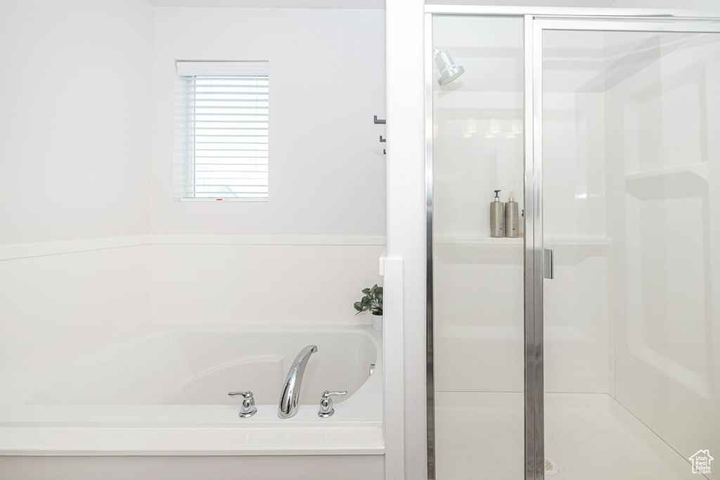Bathroom featuring a shower stall and a bath