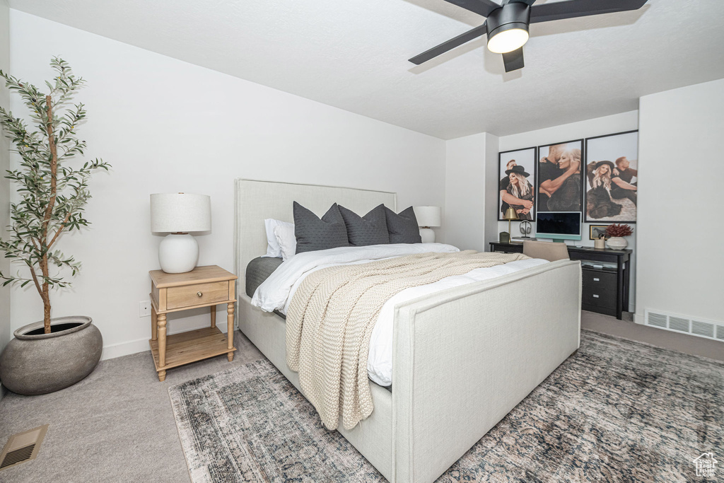 Bedroom with light carpet, visible vents, baseboards, and a ceiling fan