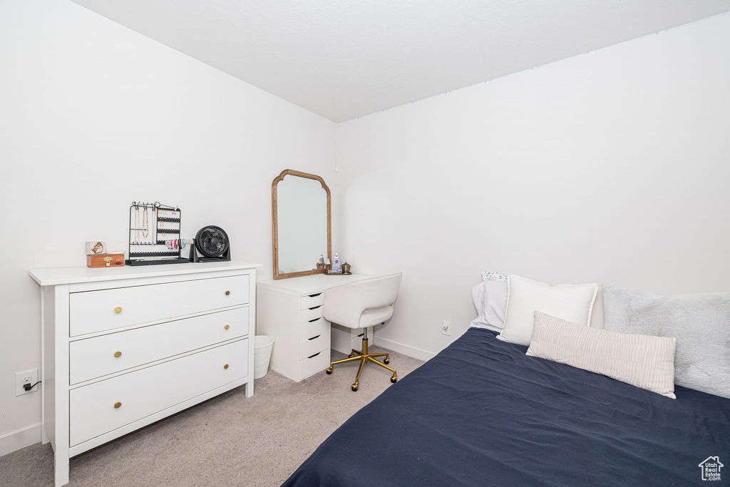 Bedroom with baseboards and light carpet