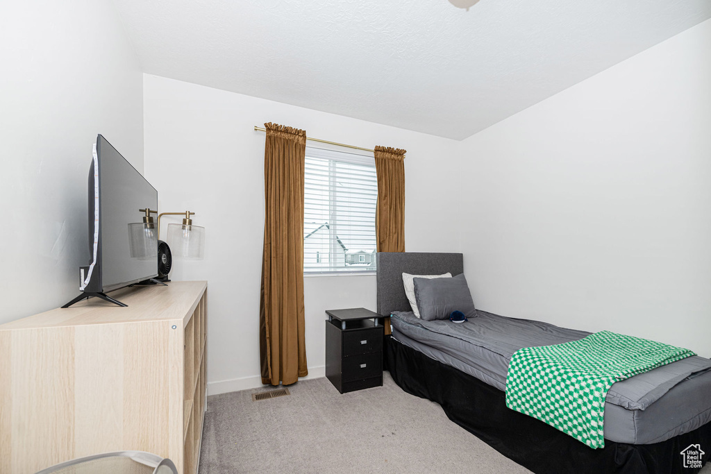 Bedroom featuring light carpet, visible vents, and baseboards