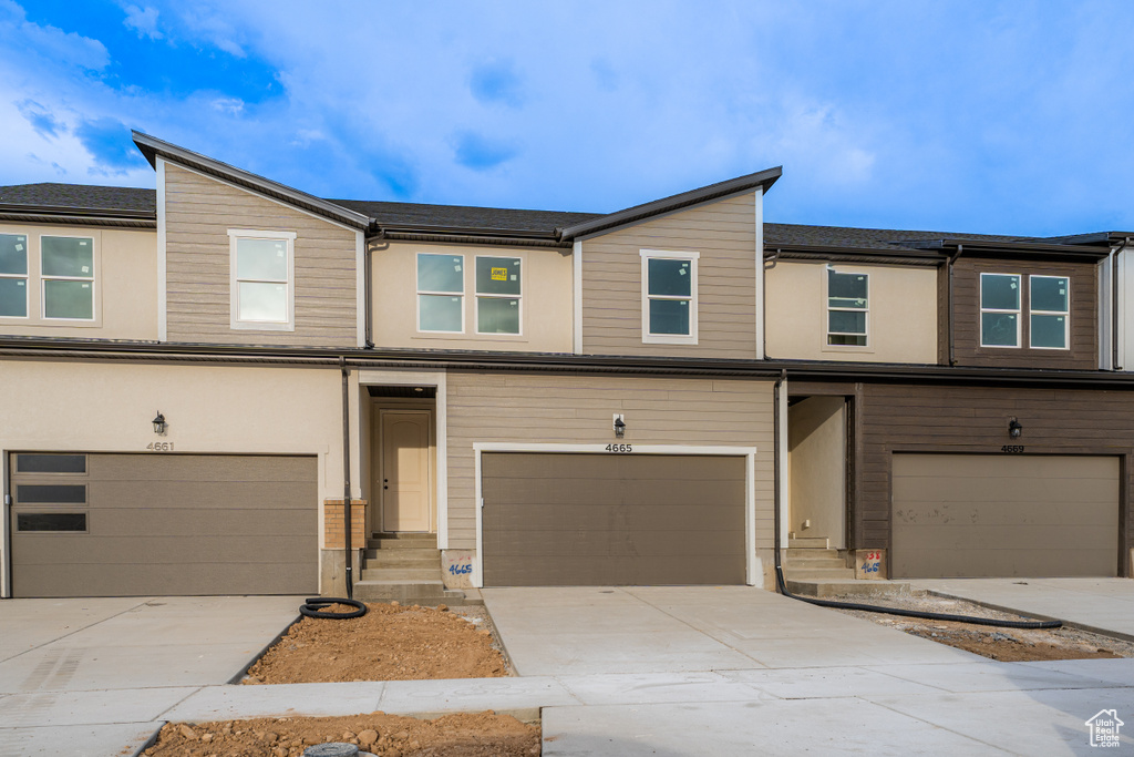 Townhome / multi-family property with an attached garage and driveway