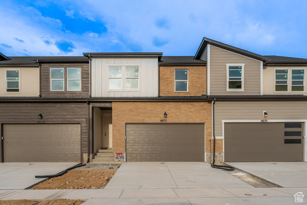 Townhome / multi-family property with an attached garage and driveway