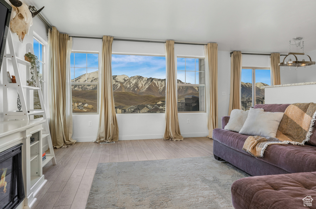 Living room with baseboards, a glass covered fireplace, hardwood / wood-style flooring, and a mountain view