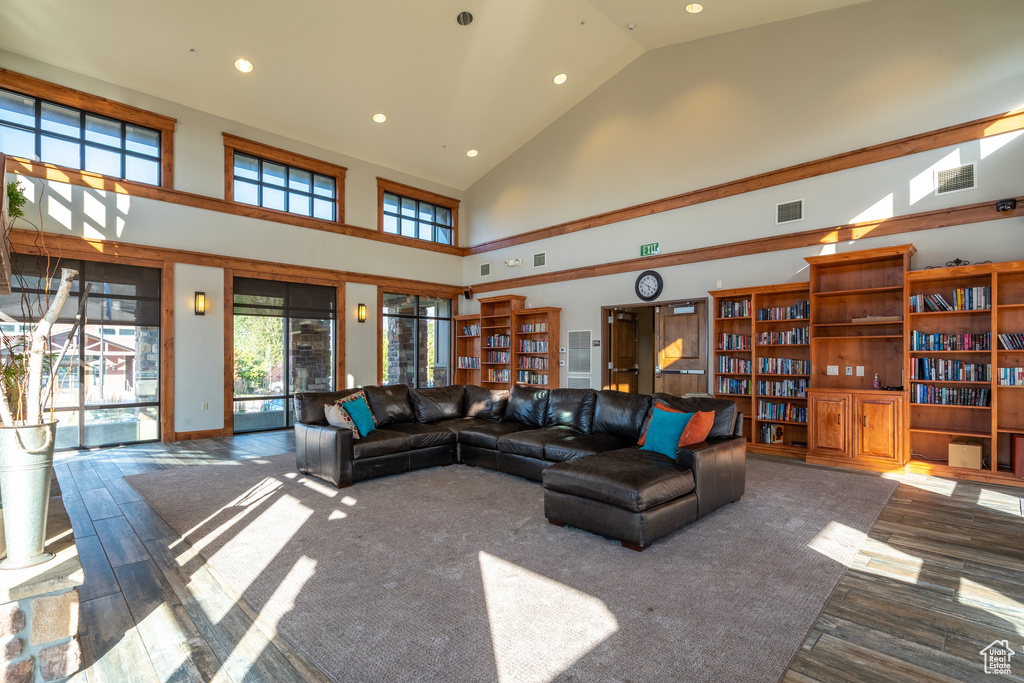 Living room with visible vents, recessed lighting, high vaulted ceiling, and wood finished floors