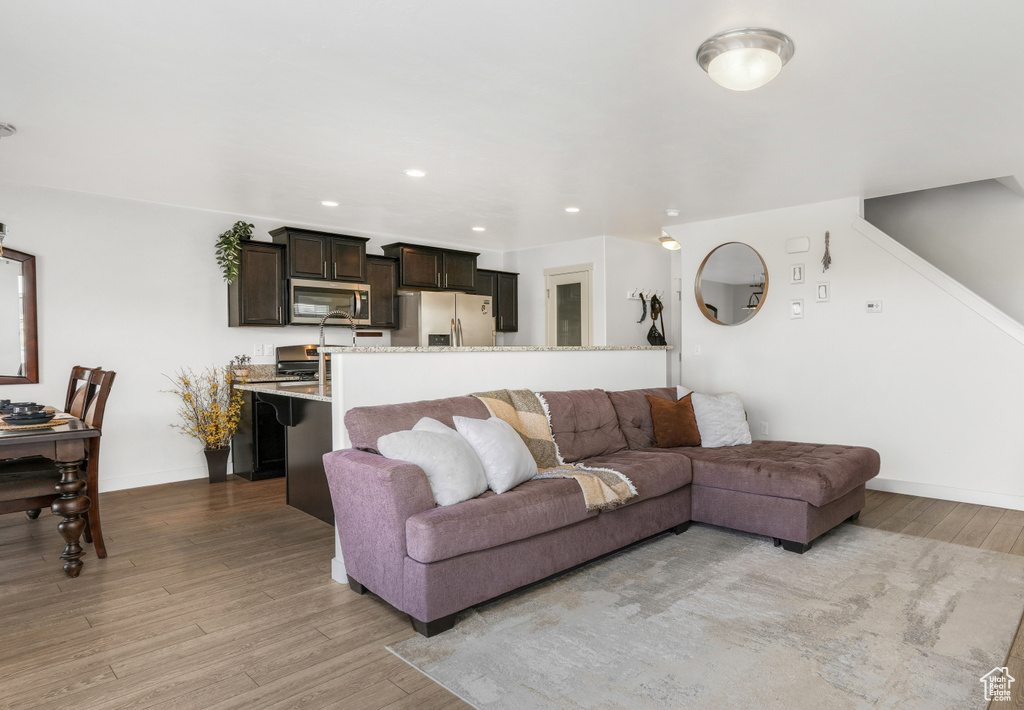 Living room with recessed lighting, light wood finished floors, and baseboards