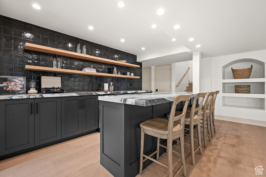 Bar with wet bar, tasteful backsplash, recessed lighting, and light wood-type flooring