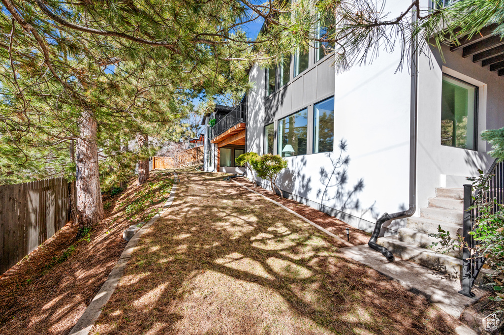 View of property exterior with stucco siding and fence