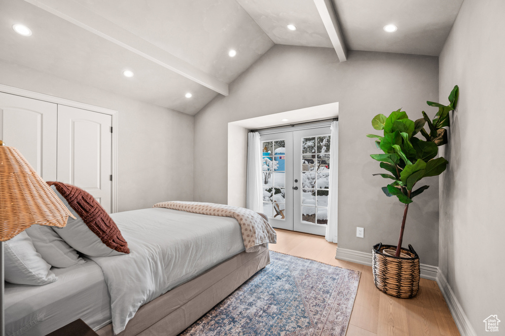 Bedroom featuring access to exterior, vaulted ceiling with beams, baseboards, french doors, and wood finished floors