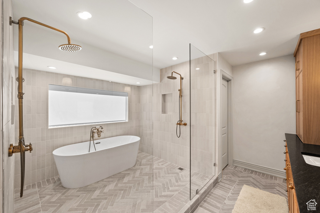 Bathroom featuring a freestanding bath, tile patterned floors, recessed lighting, and tiled shower