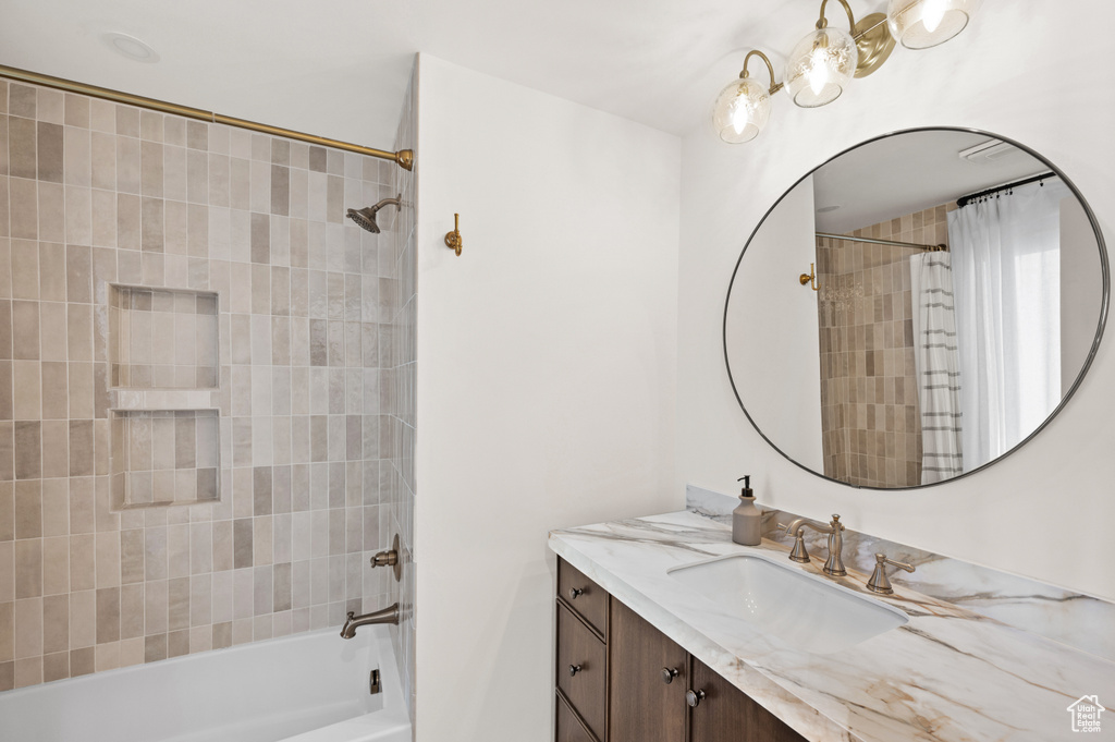 Bathroom featuring tub / shower combination, a chandelier, and vanity