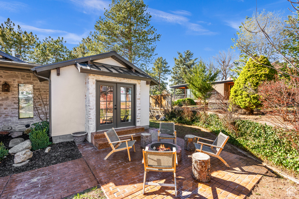 View of patio / terrace with french doors, fence, and a fire pit
