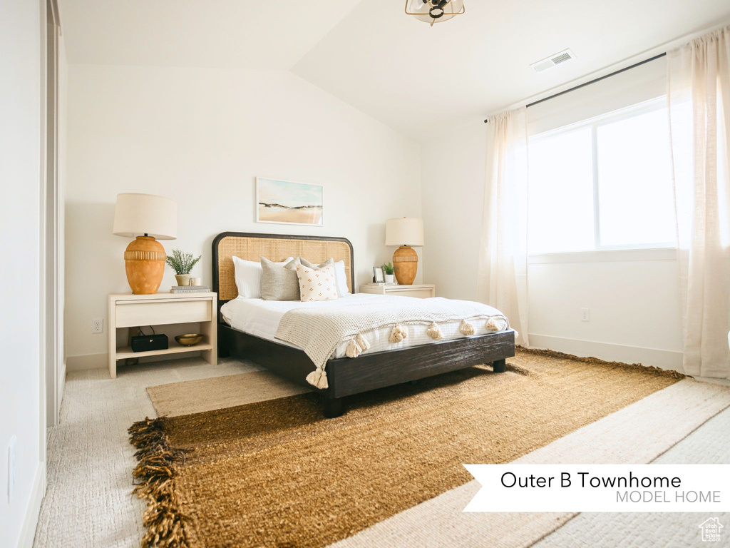 Bedroom featuring vaulted ceiling, carpet, visible vents, and baseboards