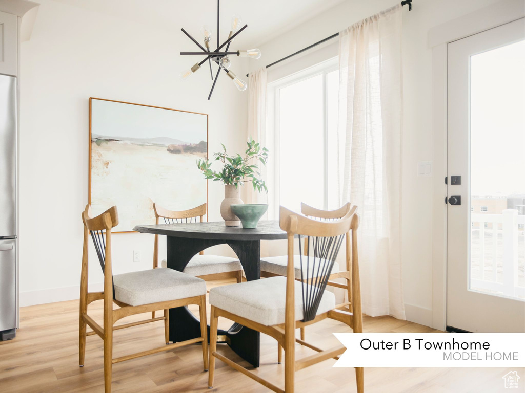 Dining area featuring light wood-style flooring, baseboards, and a chandelier