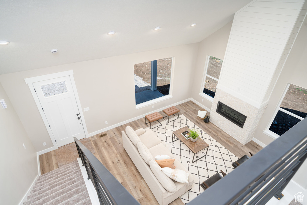 Living area featuring recessed lighting, baseboards, a glass covered fireplace, and wood finished floors