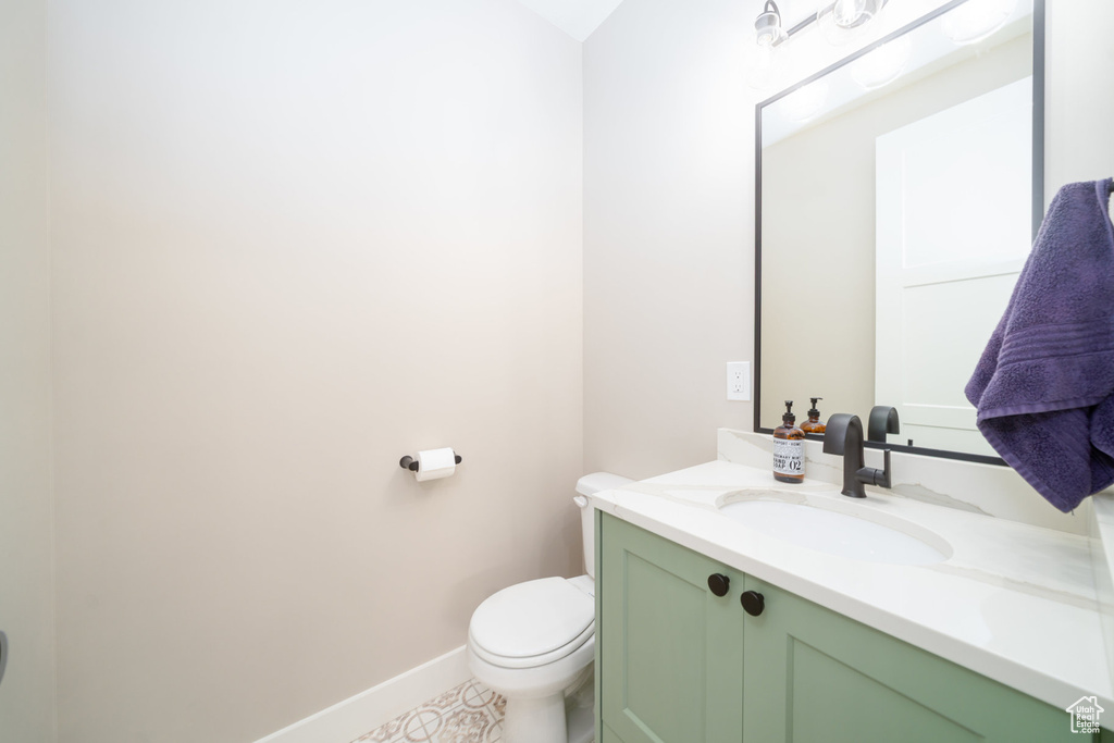 Bathroom with toilet, baseboards, and vanity