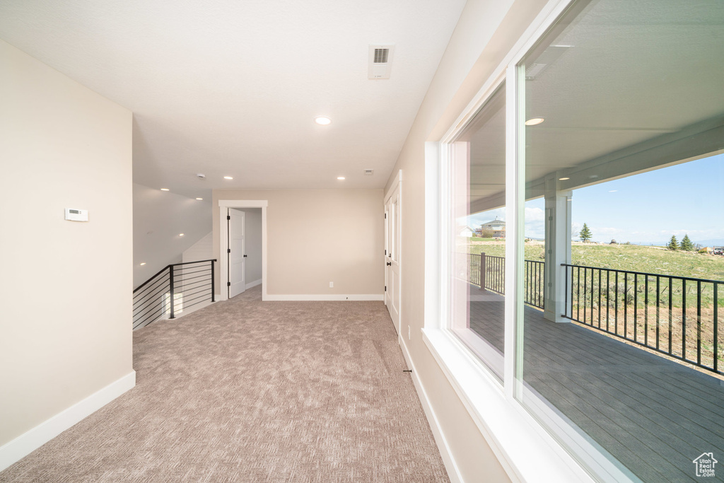Carpeted spare room with baseboards and recessed lighting