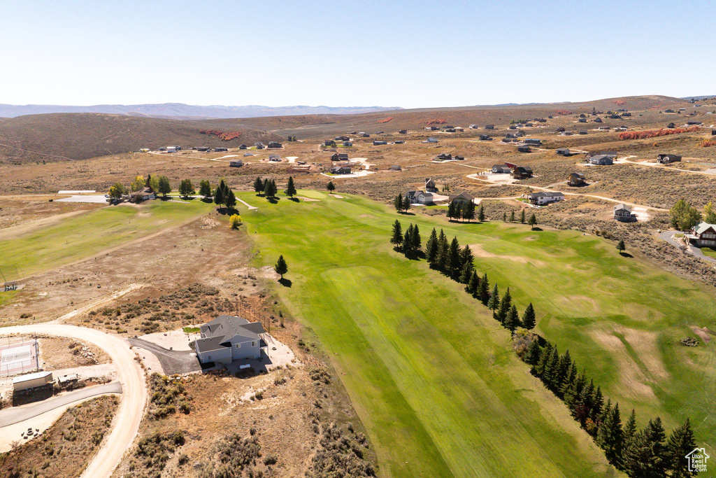 Birds eye view of property featuring a mountain view, view of golf course, and a rural view