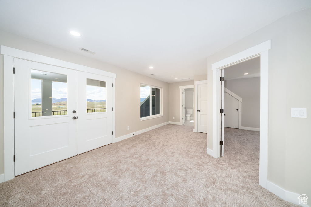 Foyer featuring light colored carpet, french doors, visible vents, and recessed lighting