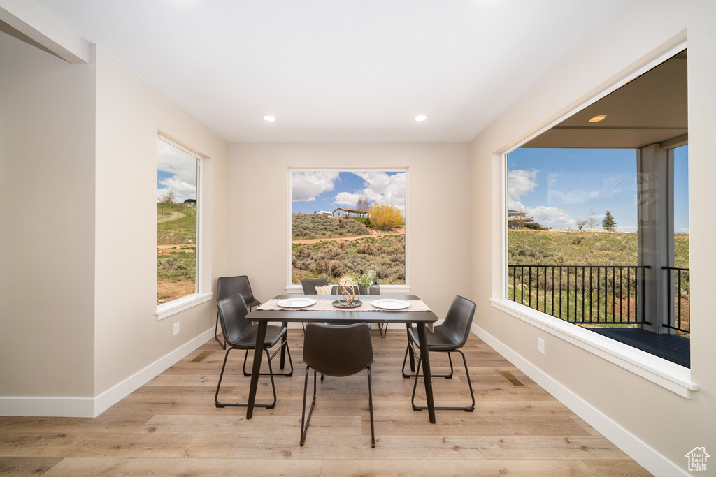 Dining space with baseboards, light wood finished floors, and recessed lighting