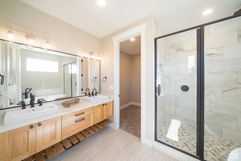 Full bathroom with a shower stall, double vanity, and a sink