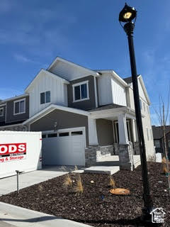 View of front of house featuring a garage, board and batten siding, and driveway