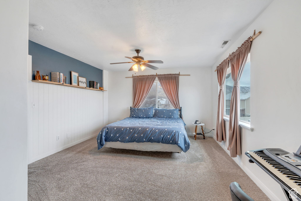 Carpeted bedroom with visible vents and a ceiling fan