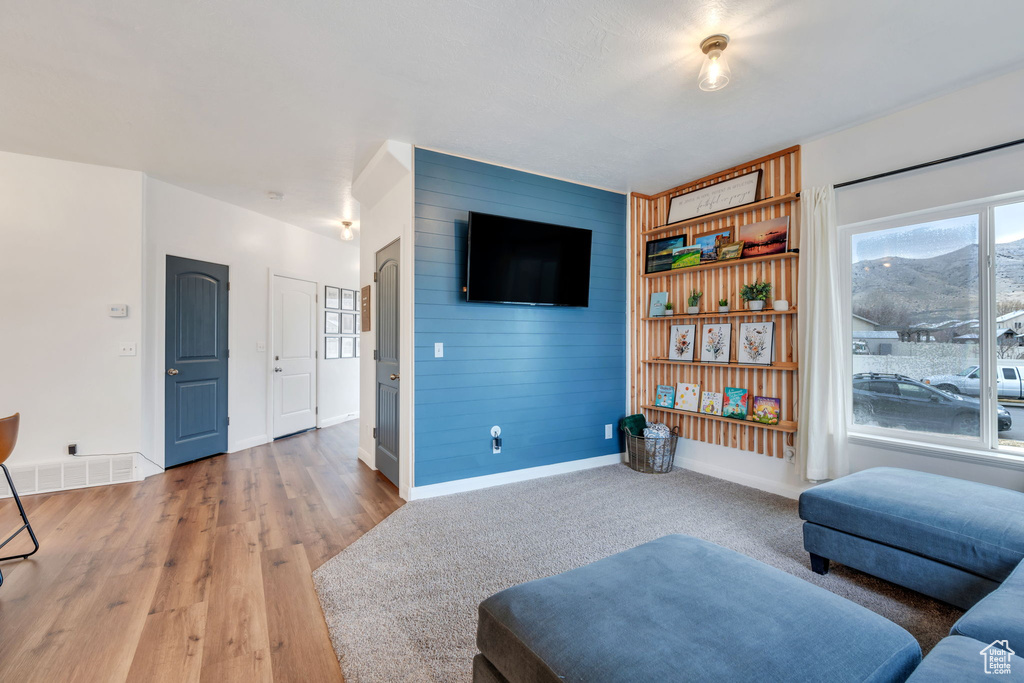 Interior space with wood finished floors, wooden walls, baseboards, and visible vents