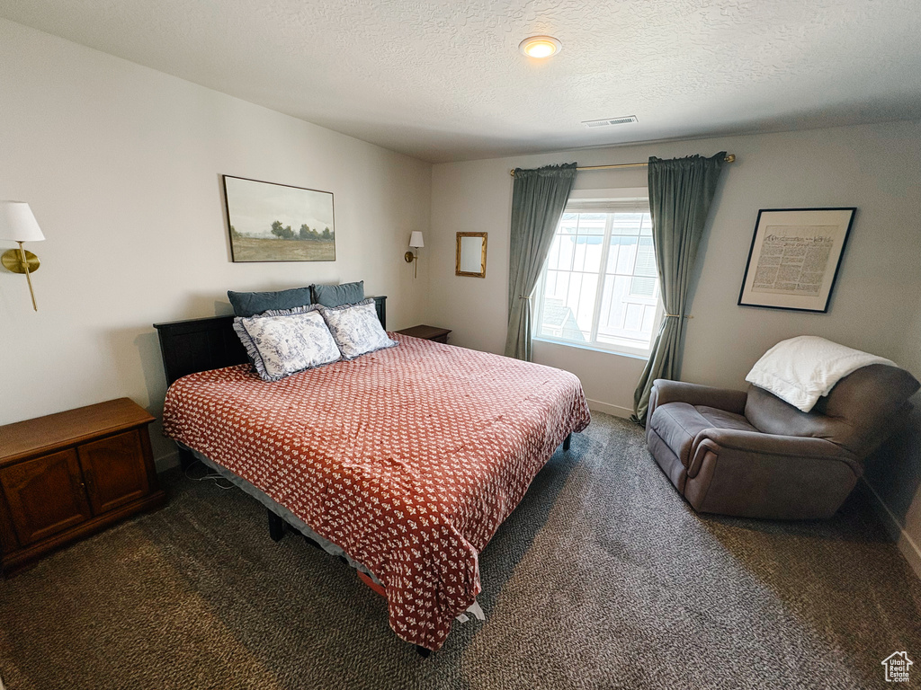 Bedroom featuring visible vents, baseboards, carpet, and a textured ceiling