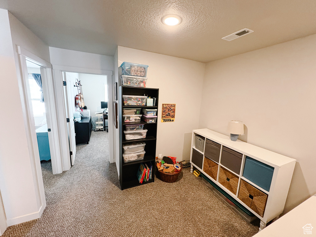 Playroom with visible vents, a textured ceiling, and carpet