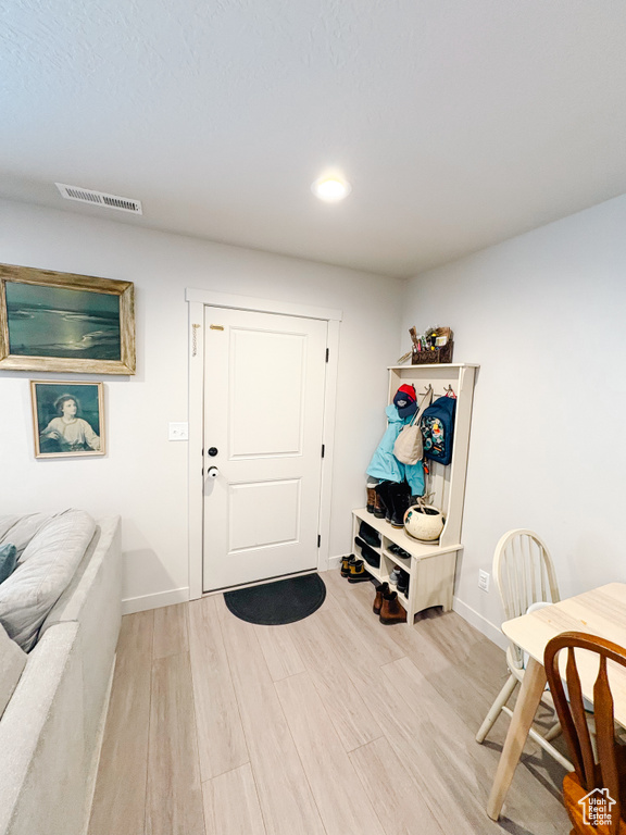 Entrance foyer with visible vents, baseboards, and light wood-style floors