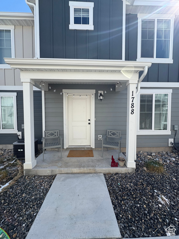 Entrance to property featuring covered porch and board and batten siding