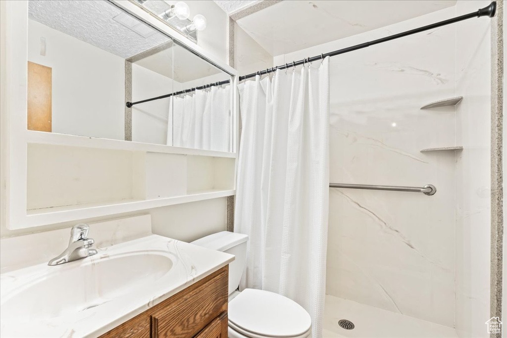 Full bath with vanity, toilet, and a stall shower